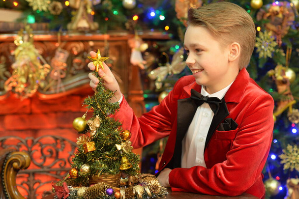 Portrait of little boy with   Christmas tree - 写真・画像