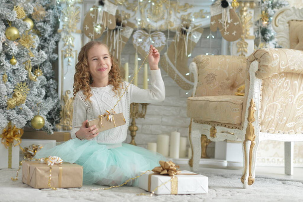 Portrait of happy   girl  sitting with gifts on Christmas - Фото, изображение
