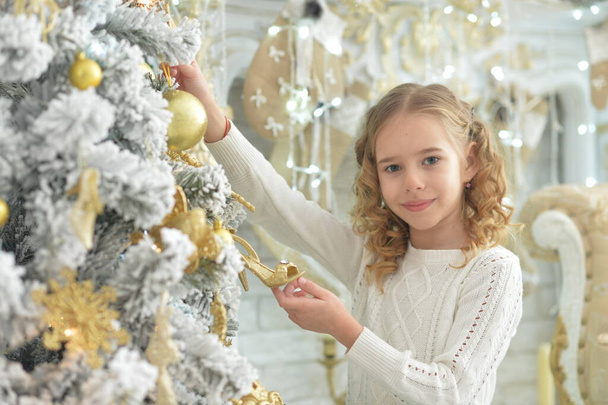 happy   girl  decorating Christmas tree at home - Fotó, kép