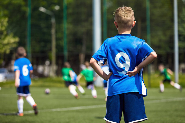 Spor sahasındaki çocuklar. Çocuklar Futbol Maçı Tekmeliyor. Okul Çağı Çocukları için Futbol Turnuvası Oyunu - Fotoğraf, Görsel