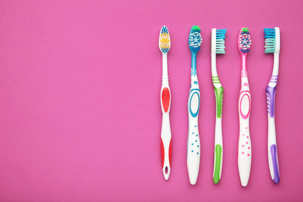 Toothbrushes on a pink background. Top view - Φωτογραφία, εικόνα