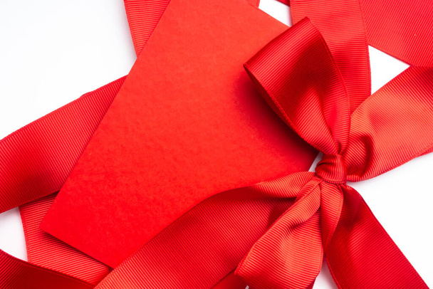 Kırmızı fiyonklu kırmızı tebrik kartı, fotokopi yeri, Sevgililer Günü, Noel, doğum günü veya parti tatili konsepti. Saten kurdeleye bağlanmış boş hediye etiketi - Fotoğraf, Görsel