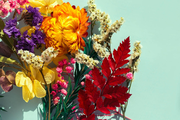 Açık mavi arkaplanda kurumuş çiçeklerle sonbahar kompozisyonu. Sonbahar, sonbahar, Şükran Günü konsepti. En üst görüntü - Fotoğraf, Görsel
