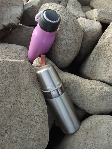 bouteilles thermoses se trouvent dans la nature sur le parking des touristes - Photo, image