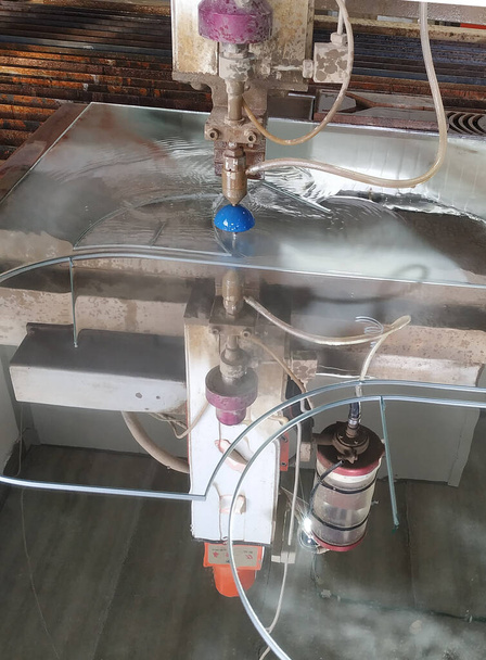 Karmaşık şekilli bir CNC makinesinde su ve kumla dekoratif ayna kesimi - Fotoğraf, Görsel