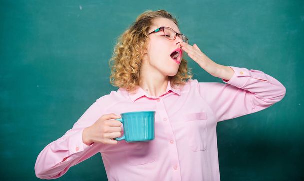 good morning. drink away your tiredness. girl refresh with drink. school teacher need coffee break. idea and inspiration. energy and vigor. energy charge. yawning woman with coffee cup at blackboard - Foto, Bild
