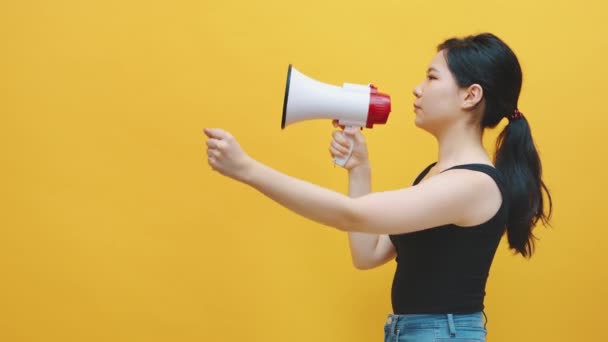 Kortingsaankondiging. Jonge Aziatische vrouwen schreeuwen in de megafoon. Kopieerruimte - Video