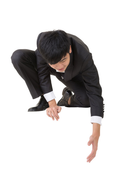 asiatischer Geschäftsmann setzt sich hin und bückt sich, um jemandem zu helfen - Foto, Bild