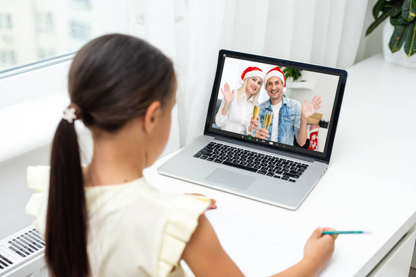 Nueva celebración navideña normal en línea. niños usando el ordenador portátil para celebrar la Navidad con el padre a través de chat de vídeo, felices fiestas, al aire libre - Foto, Imagen