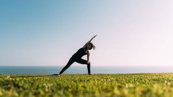 donna magra pratica yoga in luogo naturale. Copia spazio - Foto, immagini
