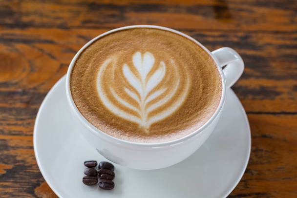 filiżanka kawy latte sztuki na drewnianym stole - Zdjęcie, obraz