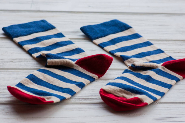 Gebreide gestreepte sokken op houten ondergrond. Comfort huishoudtextiel. sok, gebreid - Foto, afbeelding