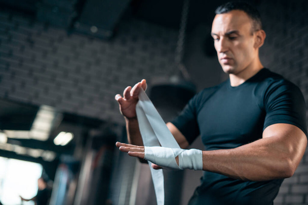 athletic boxer man bandage hand and preparing for training or fighting in gym - Photo, image