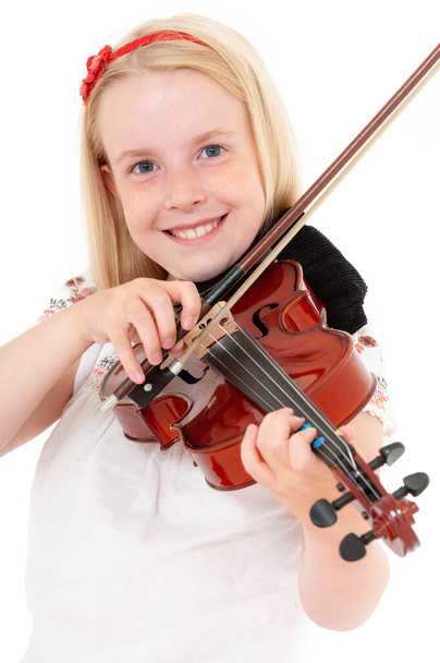 Mosolygó fiatal szőke lány játszik hegedű egy fehér stúdió háttér. - Fotó, kép