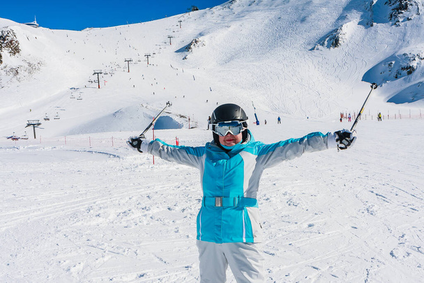 Szczęśliwa kobieta w niebieskiej kurtce na szczycie pokrytego śniegiem ośrodka narciarskiego Grandvalira w Andorze - Zdjęcie, obraz