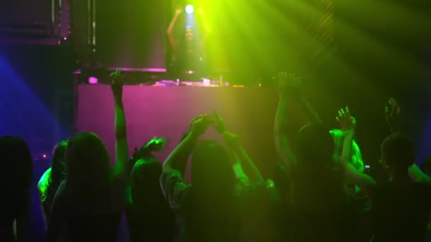 Grupo de pessoas dançam em discoteca à batida de música de DJ no palco - Filmagem, Vídeo