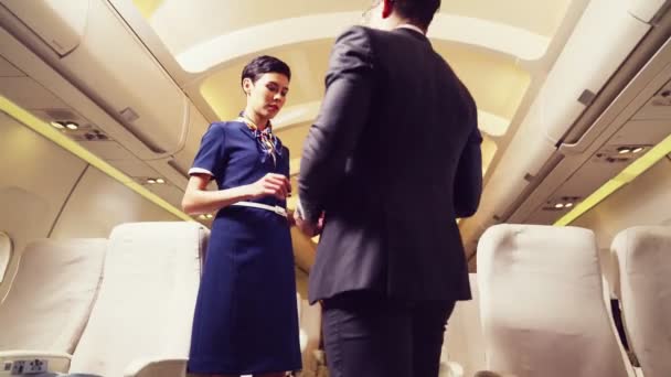 Kabinenpersonal begrüßt Passagier im Flugzeug - Filmmaterial, Video
