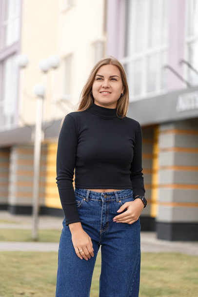 A beautiful girl with long hair in a black warm sweater. Young stylish woman in jeans culottes - Foto, afbeelding