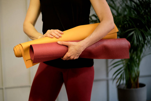 Egy fiatal nő jóga szőnyeggel a kezében. nő gyakorló jóga koncepció természetes egyensúly a test és a mentális fejlődés. - Fotó, kép