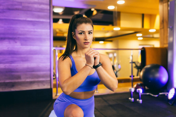 young sexy girl doing fitness warm-up in the gym, and stretching on a mat - Photo, image