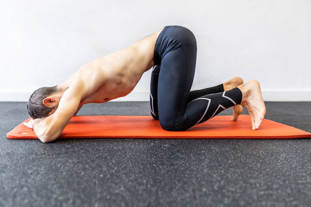 білий молодий дорослий чоловік тренує гіпопресивні вправи живота на килимку
 - Фото, зображення