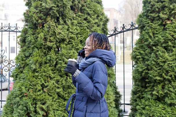 der fröhliche Afroamerikaner geht im Winter die Straße entlang - Foto, Bild