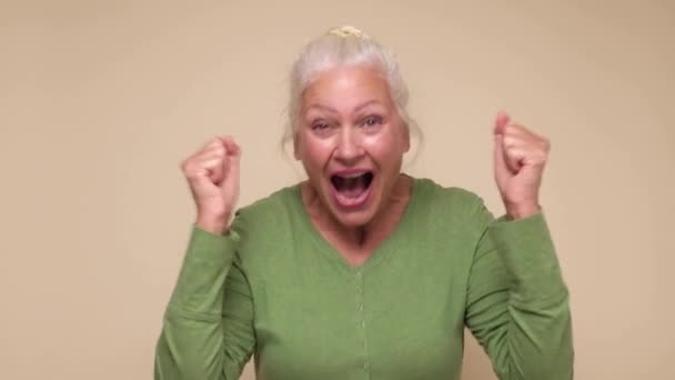 Excited senior woman screaming laughing make fists gesture Yes, getting what she wants succeed. - Footage, Video