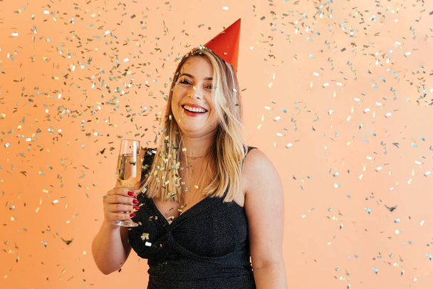 Portrait of young woman wearing party hat over colored background - Fotografie, Obrázek