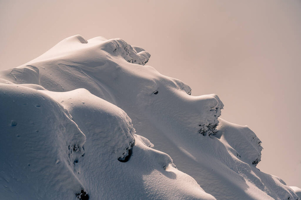 Odizolowana skała pokryta śniegiem w zimie. Lodowce 3000, Diablerets w Szwajcarii. - Zdjęcie, obraz