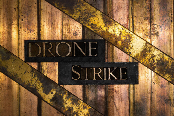 Drone Strike текст на текстурированной бронзе с гранж меди и винтажного золота фон  - Фото, изображение