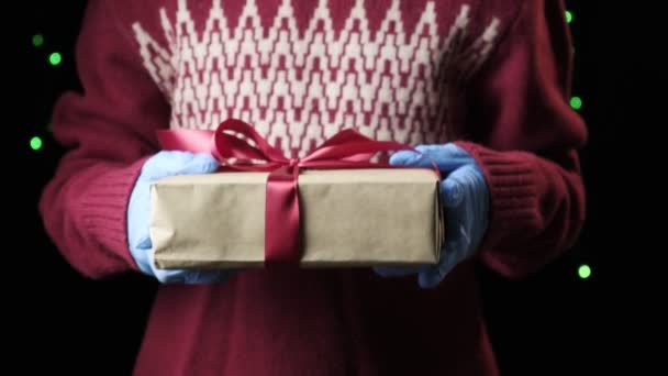 childs manos dando caja roja con cinta blanca. navidad, concepto de año nuevo - Imágenes, Vídeo