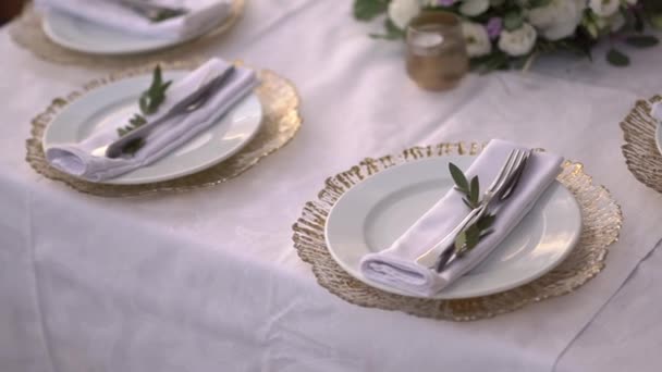 table setting at a wedding banquet decorated with olive branches and lisianthus flowers - Footage, Video