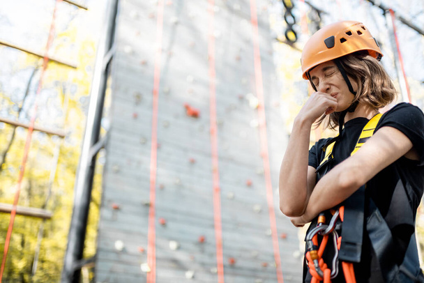 Donna spaventata vicino alla parete di arrampicata - Foto, immagini