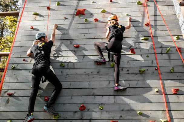 Férfiak és nők másznak a falra a parkban - Fotó, kép