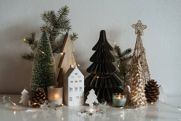 Wesołych Świąt. Boże Narodzenie mały ceramiczny dom, drewniane jodły.  - Zdjęcie, obraz