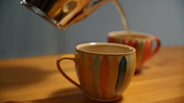Versare il tè in una tazza di tè. Persona versa il tè in una bella tazza di tè vintage. - Filmati, video