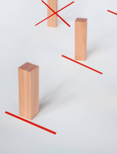 社会的距離概念。広い間隔で赤い線と近くに立って木製のブロックおもちゃ. - 写真・画像
