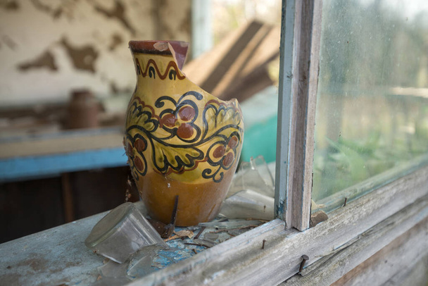 Старая разбитая посуда в доме заброшенного села Старосилья, Чернобыльская зона отчуждения, Украина - Фото, изображение