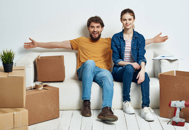 joven pareja sentado en blanco sofá cajas moviendo estilo de vida - Foto, imagen