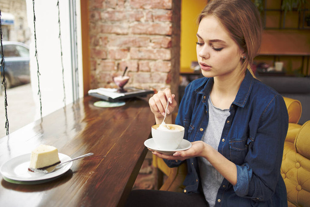 mulher sentada a uma mesa em um café uma xícara de bebidas estilo de vida comunicação manhã - Foto, Imagem