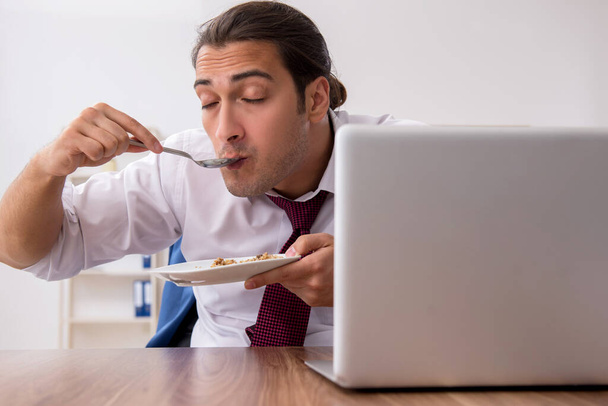 Nälkä mies työntekijä syö tattari tauon aikana - Valokuva, kuva
