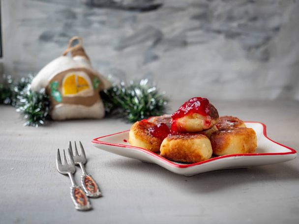 Petit déjeuner le matin de Noël. Gâteaux au fromage avec confiture de baies et décorations de Noël pour l'humeur - Photo, image