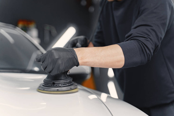 Man polish a car in a garage - Fotó, kép