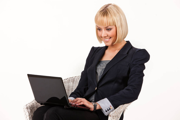 Young beautiful woman working at the laptop on an isolated studio background - Photo, Image