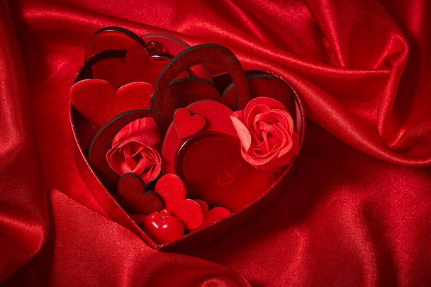 όμορφη κόκκινη διακόσμηση για την ημέρα του Αγίου Βαλεντίνου στο κόκκινο μετάξι ύφασμα  - Φωτογραφία, εικόνα