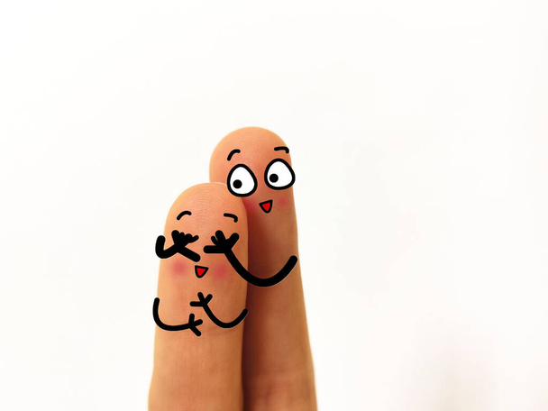 Deux doigts sont décorés comme deux personnes. L'un d'eux en surprend un autre. - Photo, image