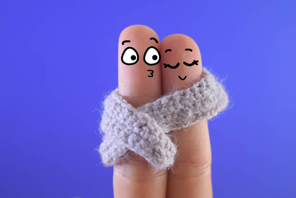 Kaksi sormea on sisustettu kaksi henkilöä. He jakavat huivi, kun he ovat dating. - Valokuva, kuva