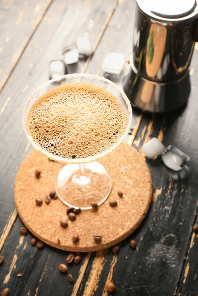 Copa de sabroso café espresso martini cóctel y géiser cafetera sobre fondo de madera - Foto, Imagen