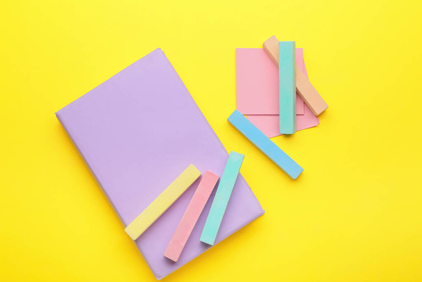 Composition with colorful chalks and notebook on color background - Foto, Imagem