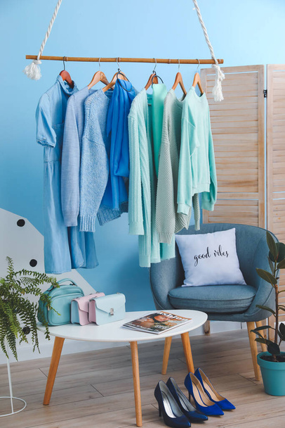 Rack with autumn clothes in interior of modern room - Photo, Image